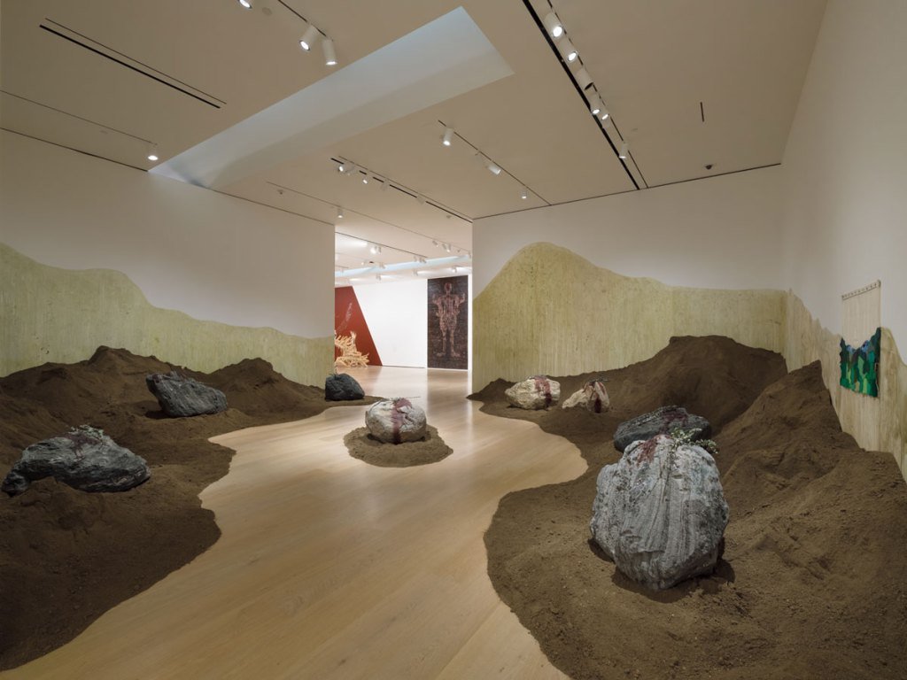 Edgar Calel, Ch'ablin nu rayb'el Chua taj ab'ej: mounds of brown humus and boulders bearing offerings in a Hammer Museum gallery