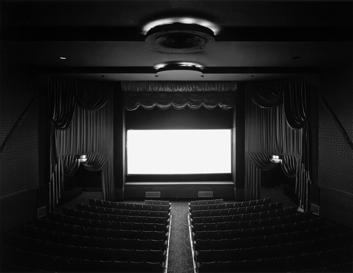 Hiroshi Sugimoto, Theaters: ảnh đen trắng nội thất một rạp chiếu cổ, màn ảnh sáng trắng rọi lên trần và hàng ghế