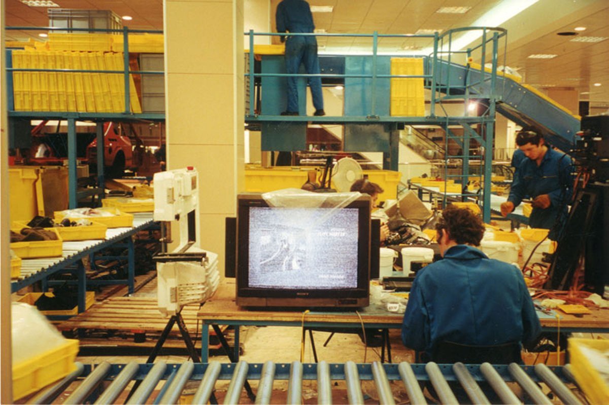 Michael Landy, Break Down: a conveyor of yellow trays carrying personal belongings in the former C&A store on Oxford Street